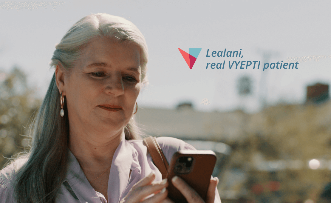 Lealani, a real VYEPTI patient, looks at her phone while outside